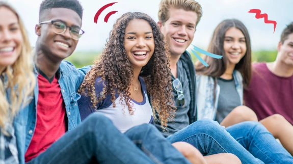 Estudiantes agrupados sonriendo al aire libre